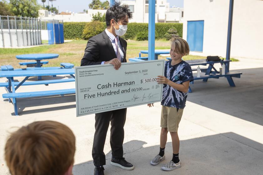 Dylan Jin-Ngo, 16, presents a check for $500 to Cash Harman.