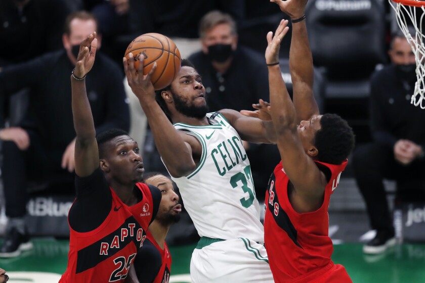 Boston Celtics' Semi Ojeleye (37) shoots against Toronto Raptors' Chris Boucher (25) and Kyle Lowry during the second half of an NBA basketball game, Thursday, Feb. 11, 2021, in Boston. (AP Photo/Michael Dwyer)