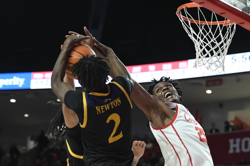 East Carolina guard Tristen Newton (2) and Houston center Josh Carlton (25) reach for a rebound during the first half of an NCAA college basketball game Saturday, Jan. 22, 2022, in Houston. (AP Photo/Justin Rex)