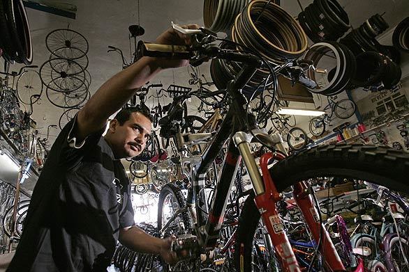 Carlos Sanchez adjusts the brakes in Dennison Cyclery on Whittier Boulevard in East Los Angeles. The shop has been in business since 1941.