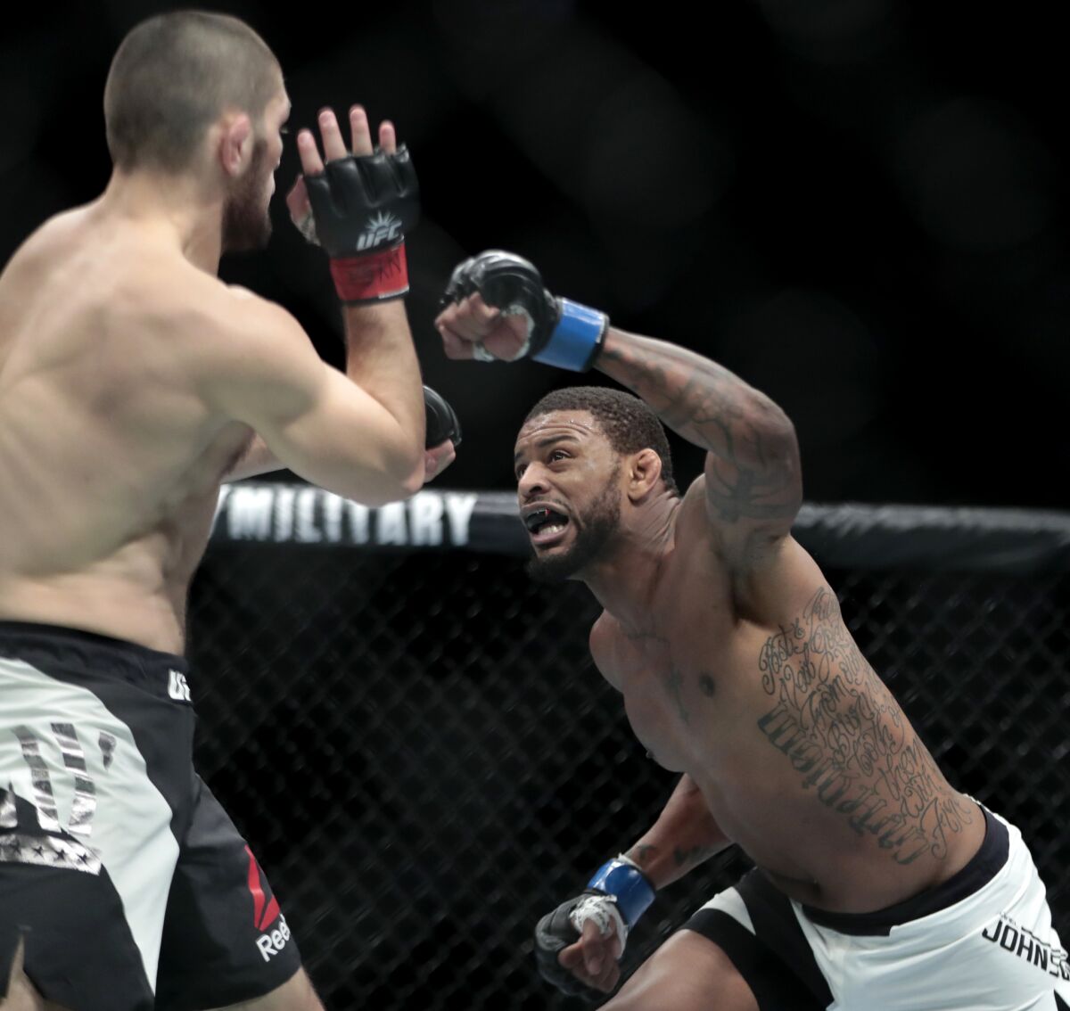 Michael Johnson lunges forward, leading with his left hand, during a lightweight bout against Khabib Nurmagomedov at UFC 205.