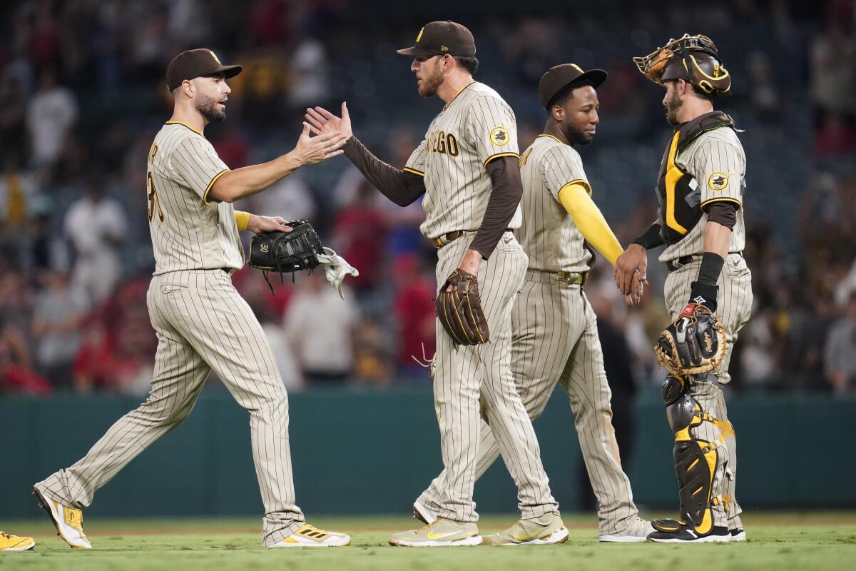 From left, the Padres' Eric Hosmer, Joe Musgrove, Jurickson Profar and Austin Nola celebrate a win Aug. 27, 2021.