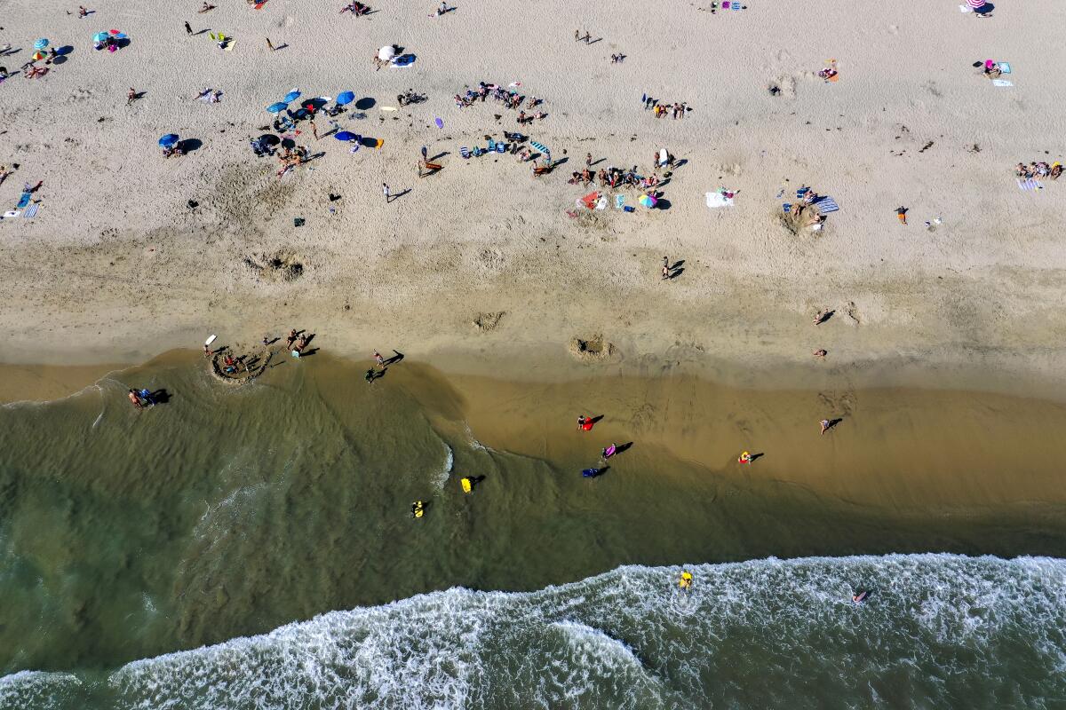 An aerial view of beachgoers enjoying a warm, sunny Saturday in Newport Beach amid state-mandated stay-at-home orders to help prevent the spread of the coronavirus pandemic.