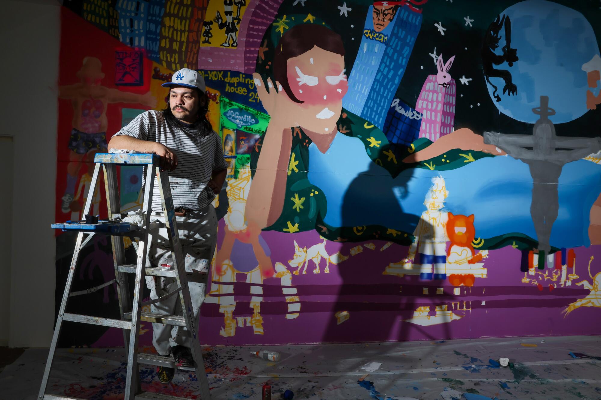 A man stands in front of one of his artworks.