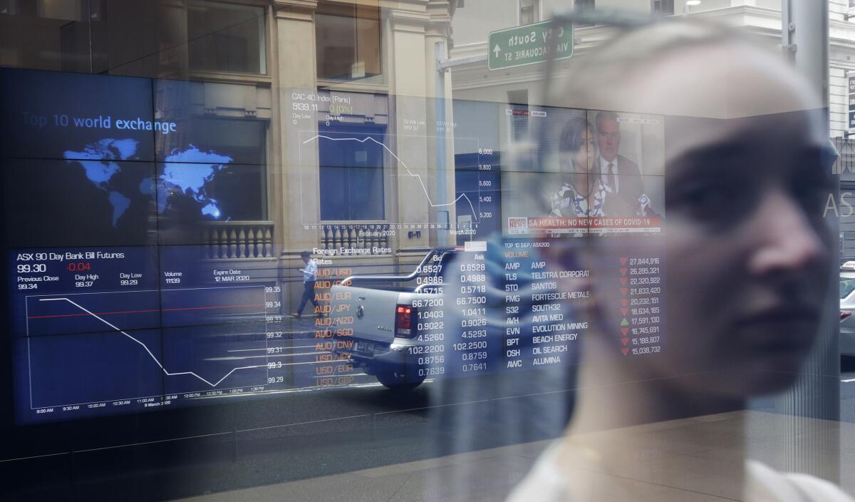 A woman's image is reflected in a window at the Australian Stock Exchange in Sydney on Monday.