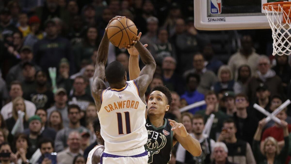Phoenix Suns' Jamal Crawford (11) hits the game-winning shot over Milwaukee Bucks' Malcolm Brogdon.