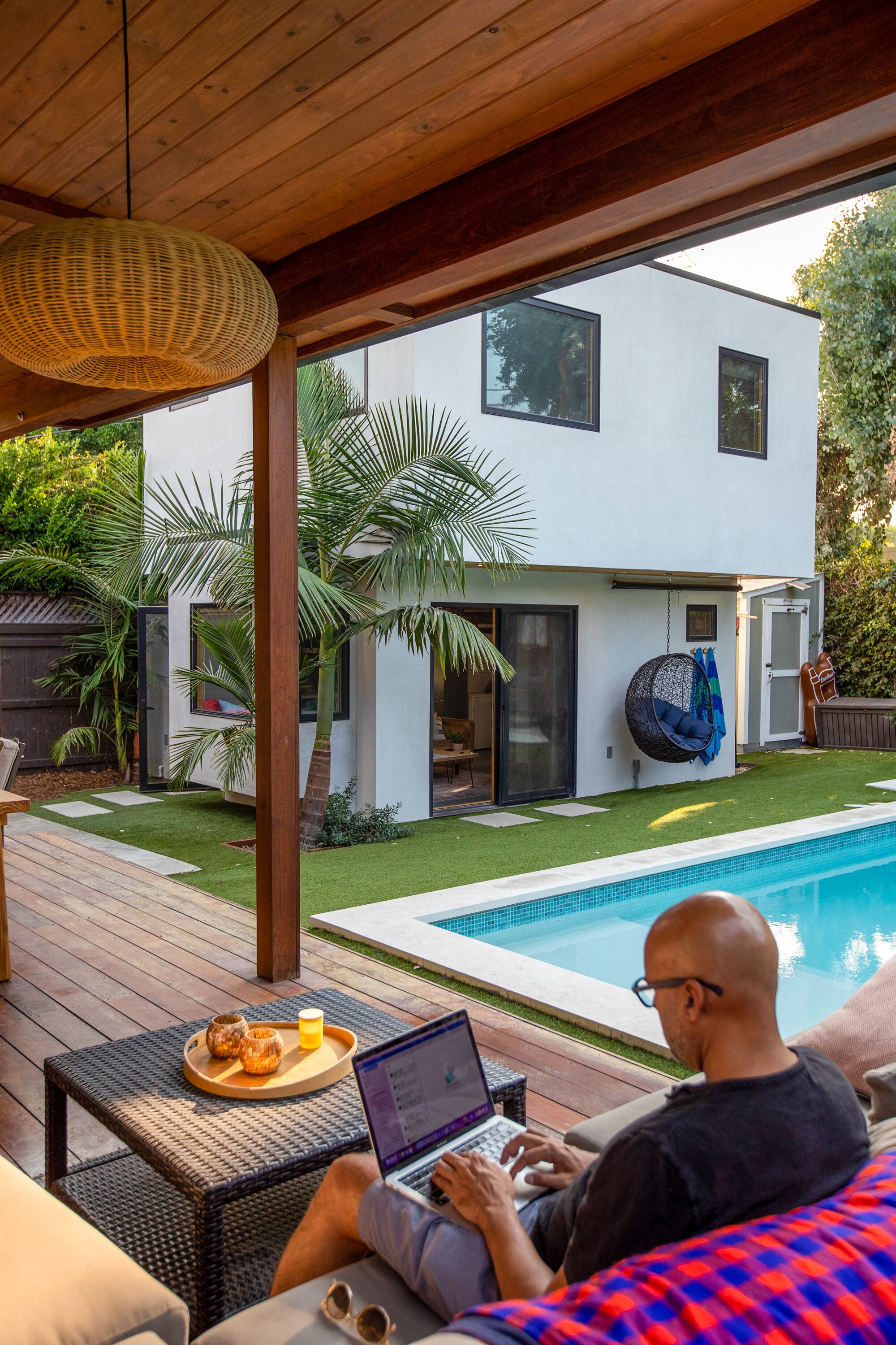 Navine Karim works outside, near the two-story poolside accessory dwelling unit.