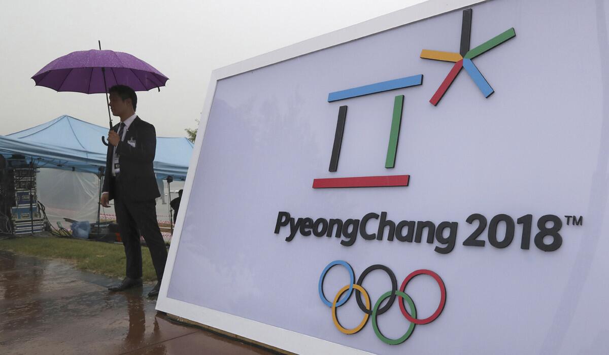 Security personnel stands by a logo of the 2018 Pyeongchang Olympic Winter Games before an event to mark the start of the 500-day countdown in Seoul, South Korea, on Sept. 27.