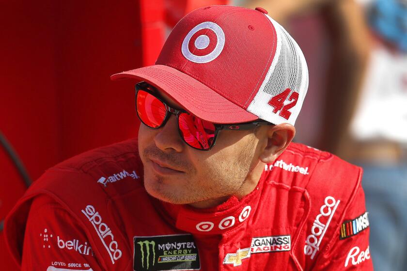 Kyle Larson talks with teammates prior to qualifying for the NASCAR Cup Series auto race in Brooklyn, Mich., Friday, Aug. 11, 2017. (AP Photo/Paul Sancya)