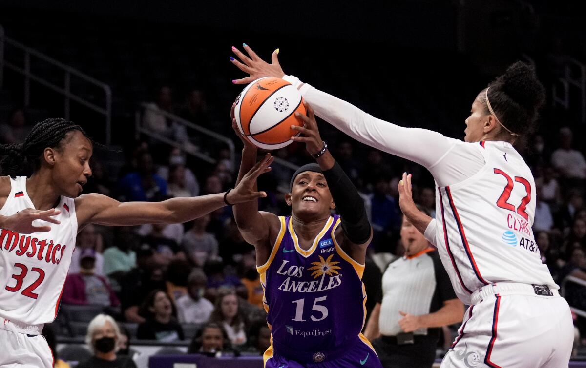 Los Angeles Sparks Brittney Sykes (15) drives between Washington Mystics guard Shatori Walker-Kimbrough (32) and forward Alysha Clark (22) during the first half of a WNBA basketball game Tuesday, July 12, 2022, in Los Angeles. (Keith Birmingham/The Orange County Register via AP)