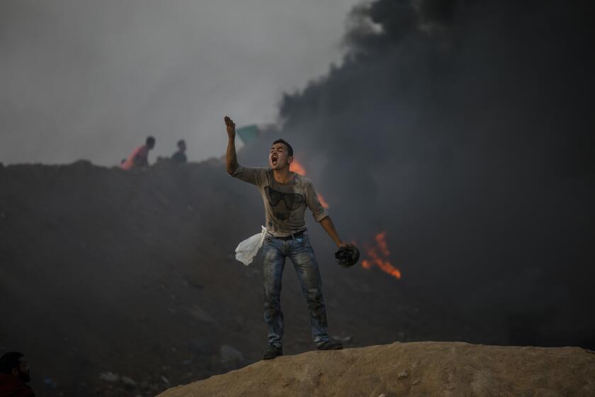 DEIR AL-BALA, GAZA -- TUESDAY, MAY 15, 2018: A Palestinian man taunts his fellow protester about not having enough courage to move forward, in Buriej, near Deir al-Bala, Gaza, on May 15, 2018. (Marcus Yam / Los Angeles Times)