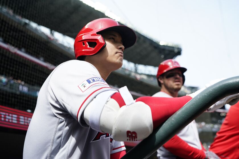 Los Angeles Angels' Shohei Ohtani stands in the dugout before facing the Seattle Mariners.