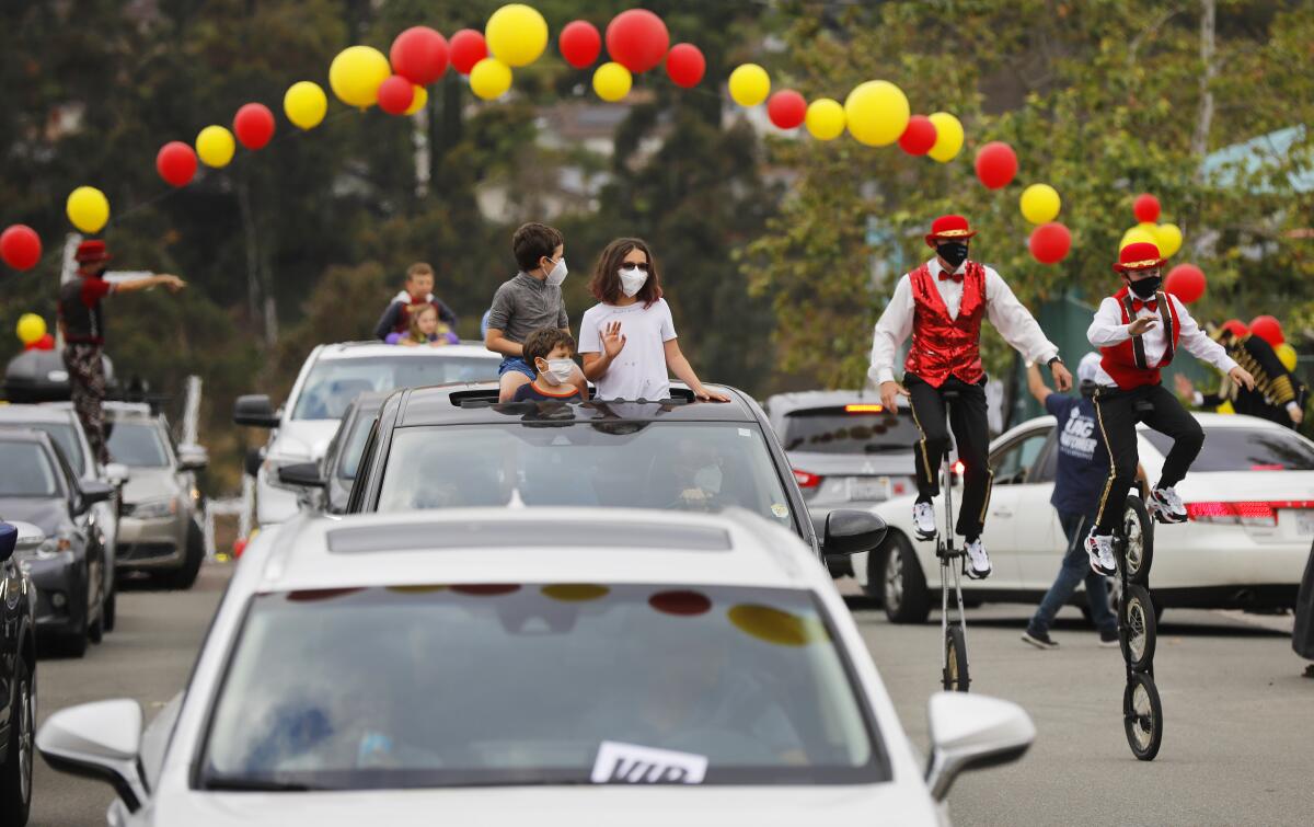 Families watch performers during a drive-thru circus to celebrate the Jewish holiday of Lag B'Omer at the Chabad San Diego campus in Scripps Ranch on May 12. Thousands of people attended the event that was complete with circus acts, live music, festival floats and a symbolic bonfire.
