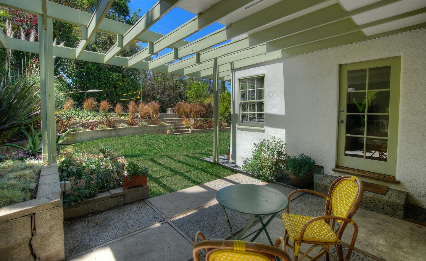 The patio with chairs and a view of the landscaped grounds.