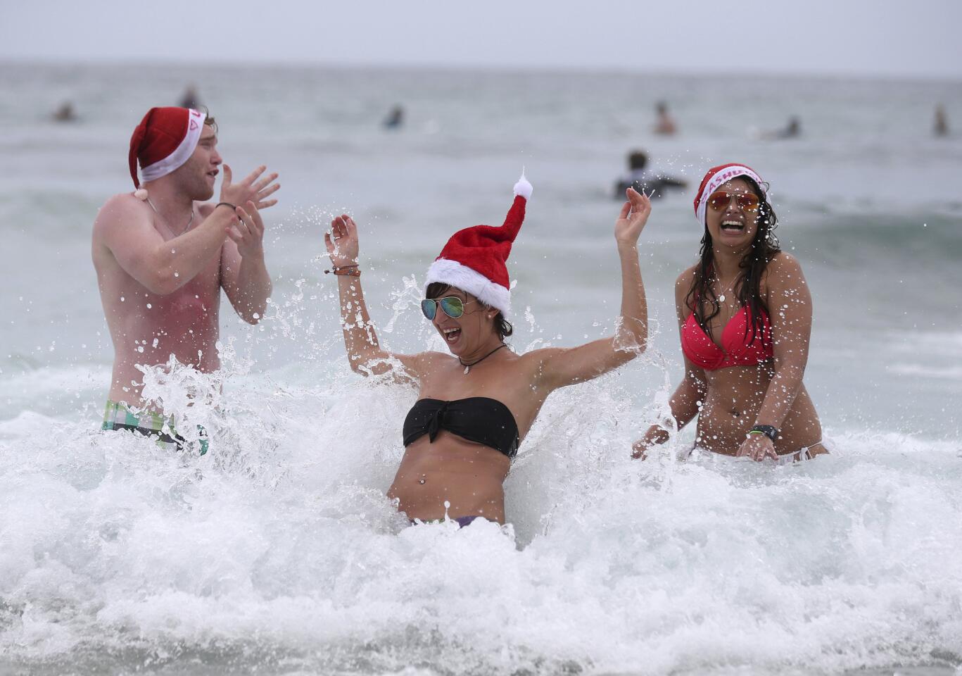 British travelers frolic in the waves as they celebrate Christmas Day at Bondi Beach in Sydney, Australia.