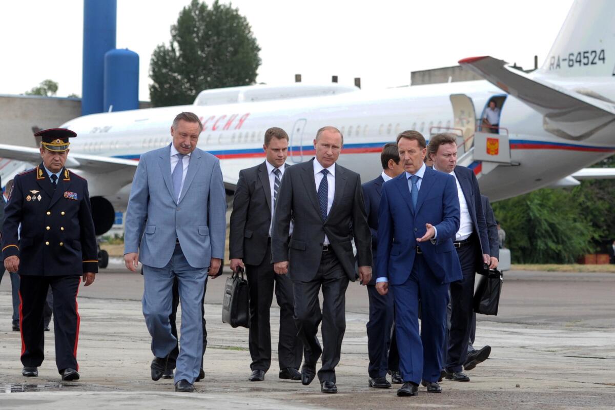 Russian President Vladimir Putin, foreground center, walks surrounded by officials upon his arrival in Voronezh, Russia, on Tuesday.