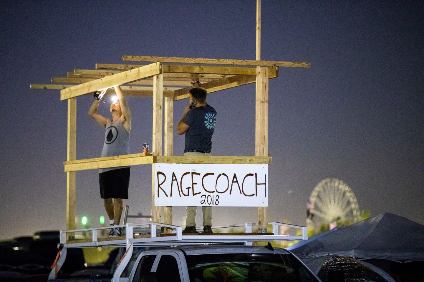 Cody Oosterbaan, let, and Steven Adam of San Diego set up a bar on top of their truck in the camping area before the start of the three-day Stagecoach festival.