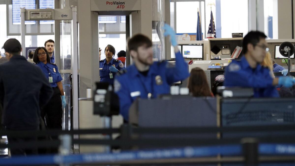 Transportation Security Administration officers work at O'Hare airport in Chicago on Jan. 5. They're not getting paid during the partial government shutdown.