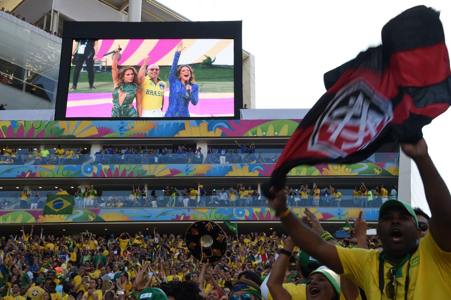 Fans cheer after the performance of (on screen, from left to right) Jennifer Lopez, Pitbull and Brazilian singer Claudia Leiite during opening ceremony of the 2014 FIFA football World Cup.