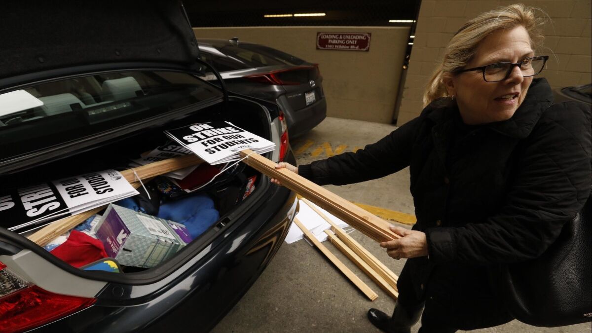Teacher Pam Baron loads up her car with picket signs after a meeting with United Teachers Los Angeles about a possible strike in Los Angeles.