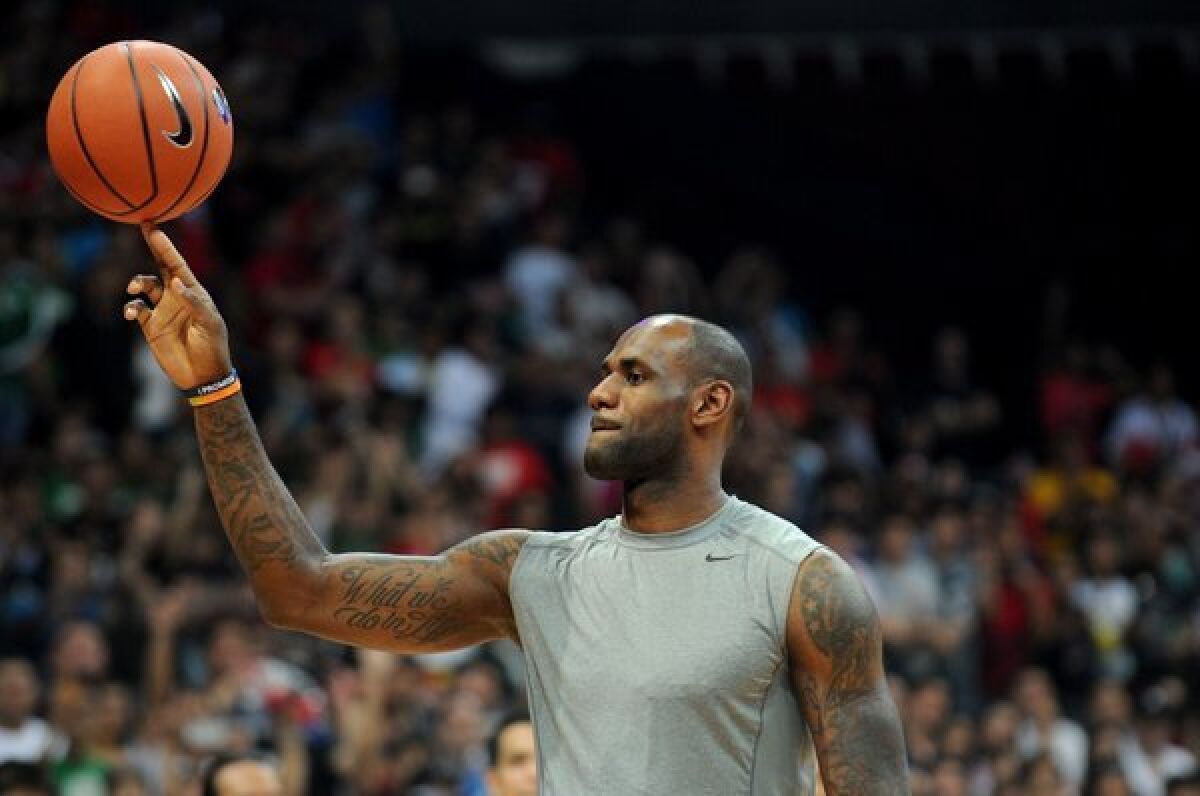 LeBron James spins a ball during a basketball clinic at the Mall of Asia Arena in Manila.