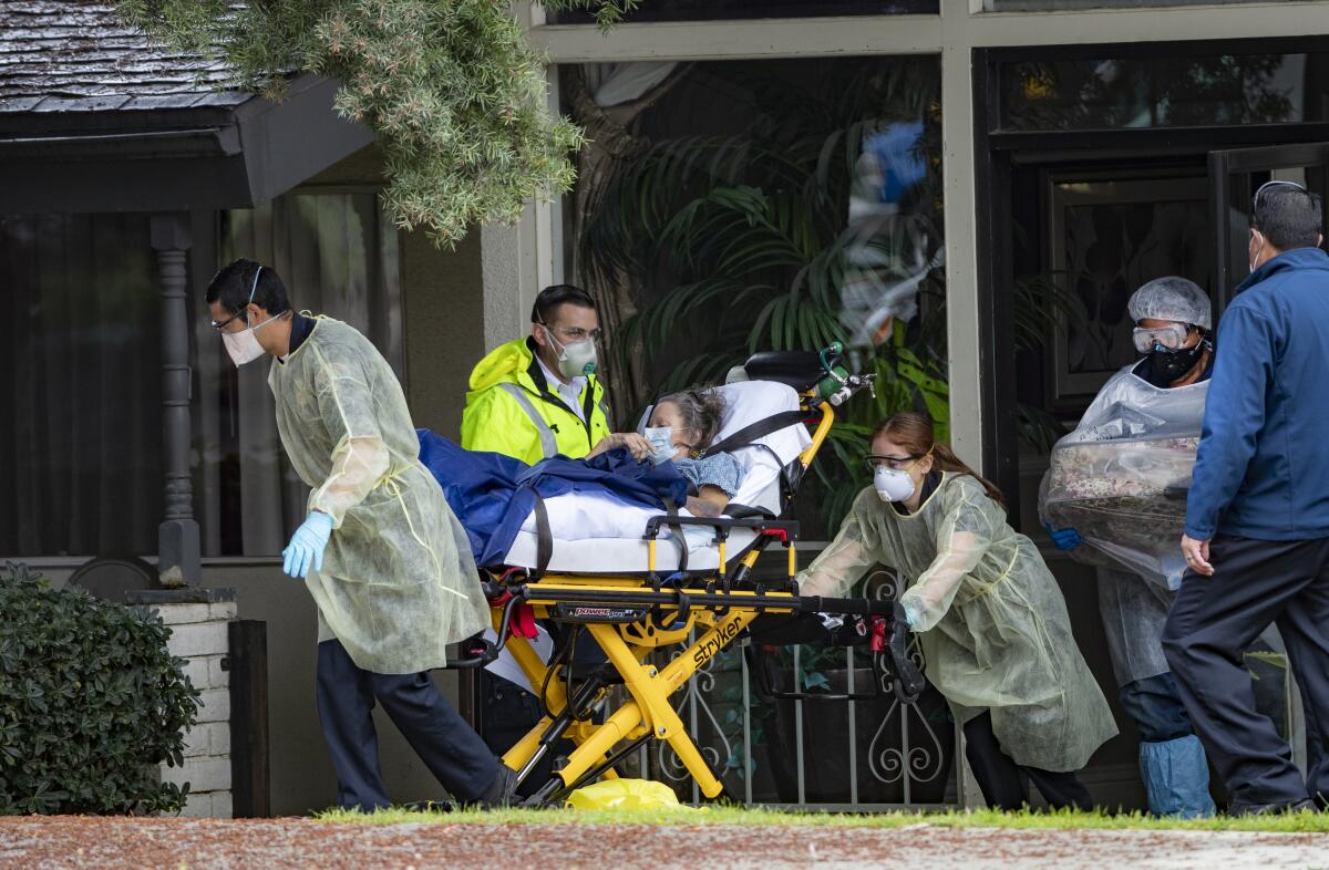 Workers remove a patient at a nursing care facility