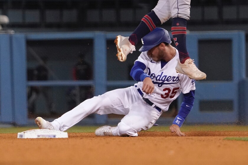 Cody Bellinger steals second as Cleveland Cavaliers second baseman Andres Gimenez leaps for a high throw.