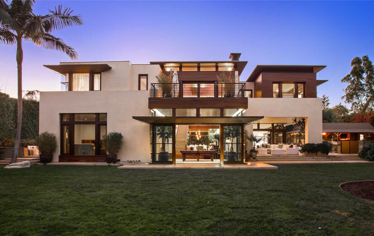 Exterior of the house with a lawn and palm tree in front.