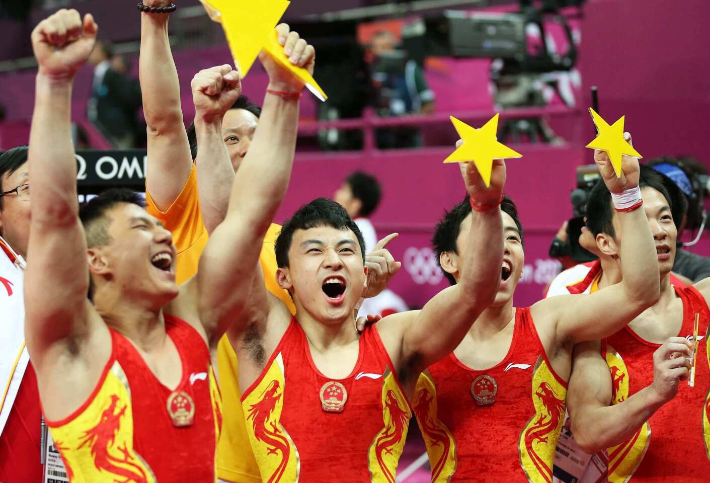 China's men's gymnastics team, from left, Zhe Feng, Weiyang Guo, Yibing Chen, Chenglong Zhang and Kai Zou celebrate winning the gold medal in the men's gymnastic team competition.
