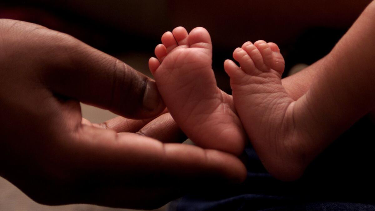 A father holds his baby girl's tiny feet on the Torres Martinez reservation.