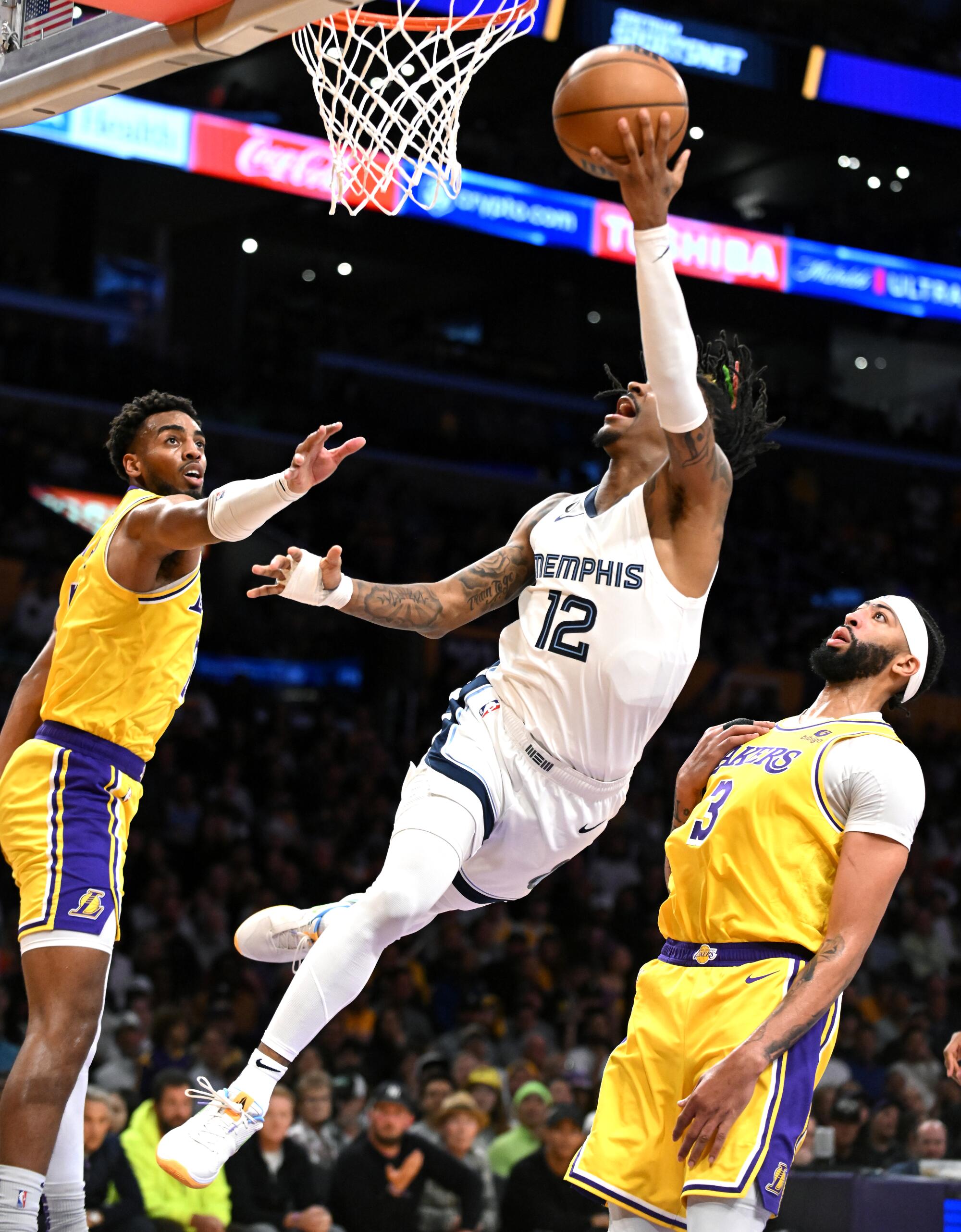The Grizzlies' Ja Morant drives between Troy Brown Jr., left, and Anthony Davis but misses the basket in the second quarter.