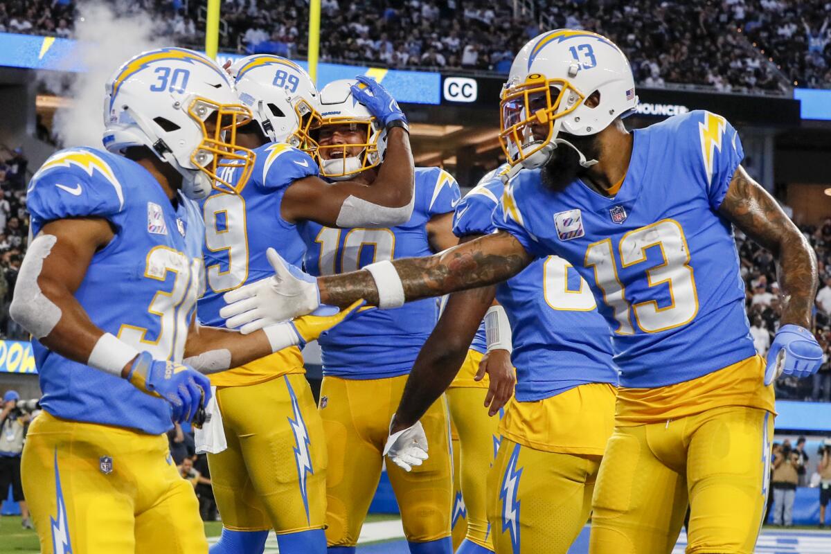 Chargers players celebrate after tight end Donald Parham (89) caught a first-quarter touchdown pass from Justin Herbert.