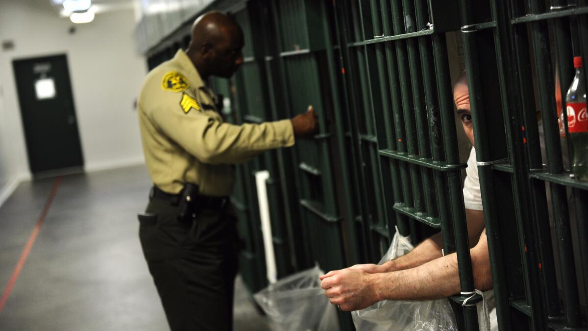An inmate peaks through the bars at the restrictive housing unit, formerly known as solitary confinement, at the Men's Central Jail in Los Angeles.