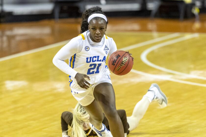 UCLA forward Michaela Onyenwere (21) gets the takeaway and scores past Wyoming guard Ola Ustowska.