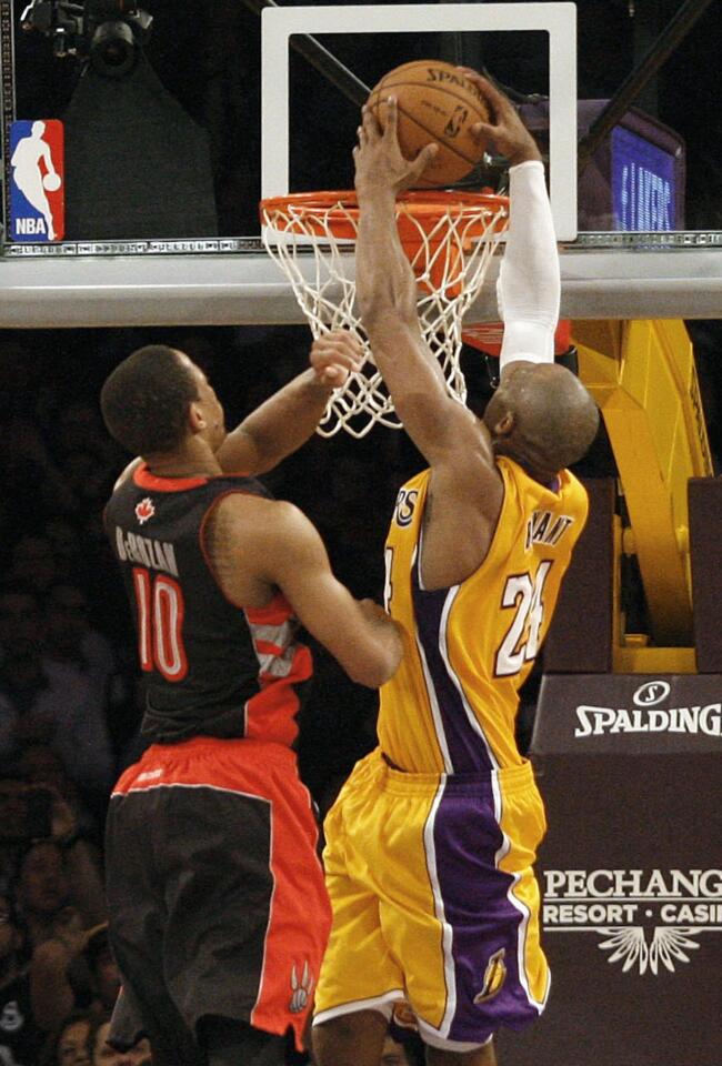 Lakers guard Kobe Bryant finishes off his 41-point night with a slam dunk against Raptors guard DeMar DeRozan in the final seconds of overtime on Friday night at Staples Center.