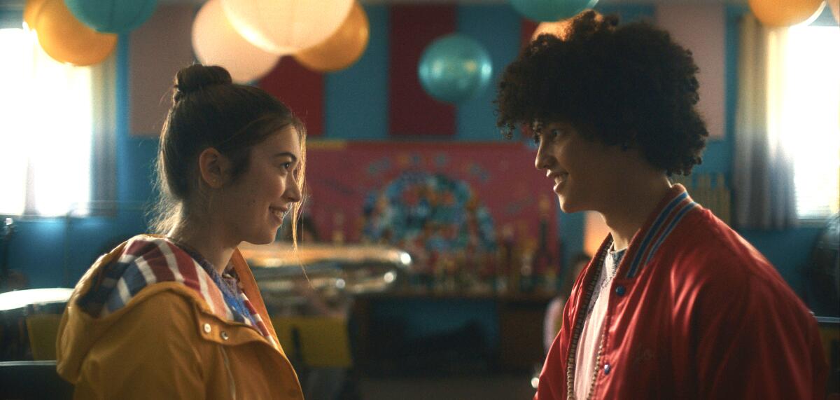 A young woman and a young man smile at one another in the movie “The Sky Is Everywhere.”