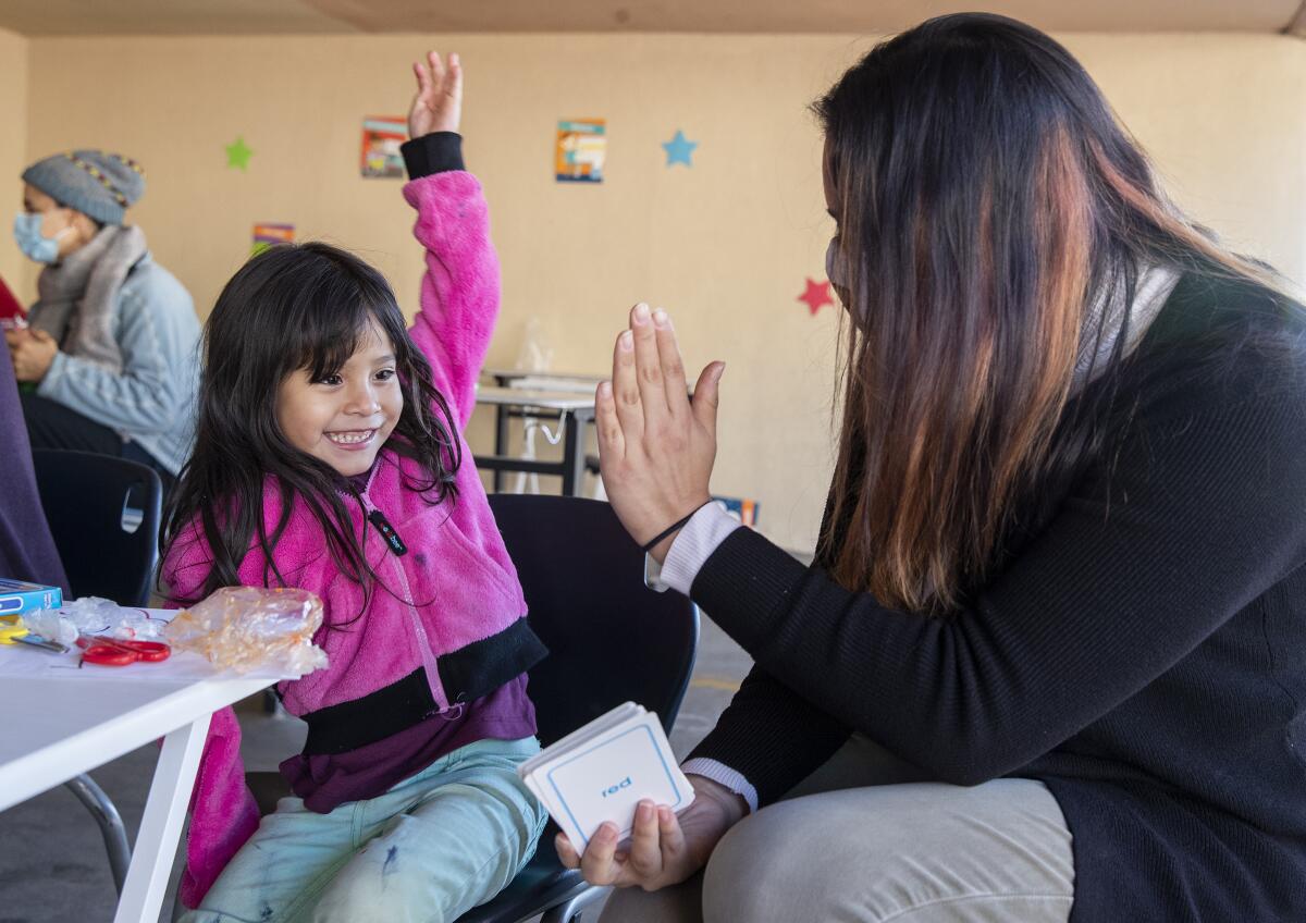 A project manager for Kids First works with a 4-year-old transitional kindergartner.
(Mel Melcon / Los Angeles Times)