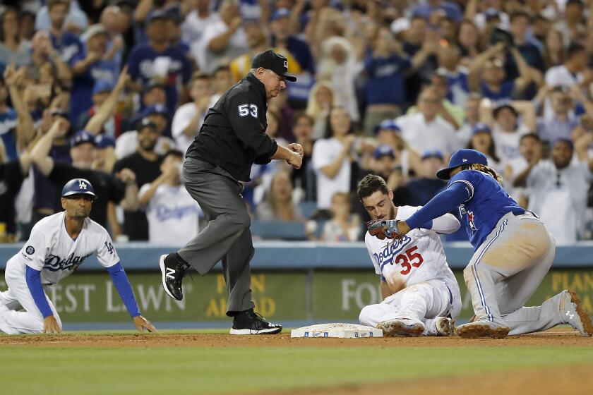 LOS ANGELES, CALIF. - AUG. 20, 2019. Blue Jays third baseman Vladimir Guerrero Jr. puts a tag on Dodgers first baseman Cody Bellinger, who tried to stretch a triple out of a two-run double in the fourth inning Tuesday night, Aug. 20, 2019, at Dodger Stadium in Los Angeles. (Luis Sinco/Los Angeles Times)