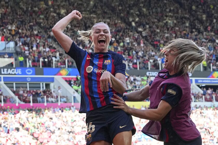 Barcelona's Fridolina Rolfo, left, celebrates after scoring her side's third goal during the Women's Champions League final soccer match between FC Barcelona and VfL Wolfsburg at the PSV Stadion in Eindhoven, Netherlands, Saturday, June 3, 2023. (AP Photo/Martin Meissner)