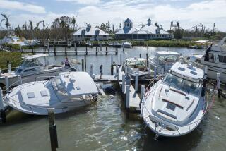 Boaters look over boats are stacked up at the Port Sanibel Marina after Hurricane Ian ran through the area Thursday, Sept. 29, 2022, in Fort Myers, Fla. (AP Photo/Steve Helber)
