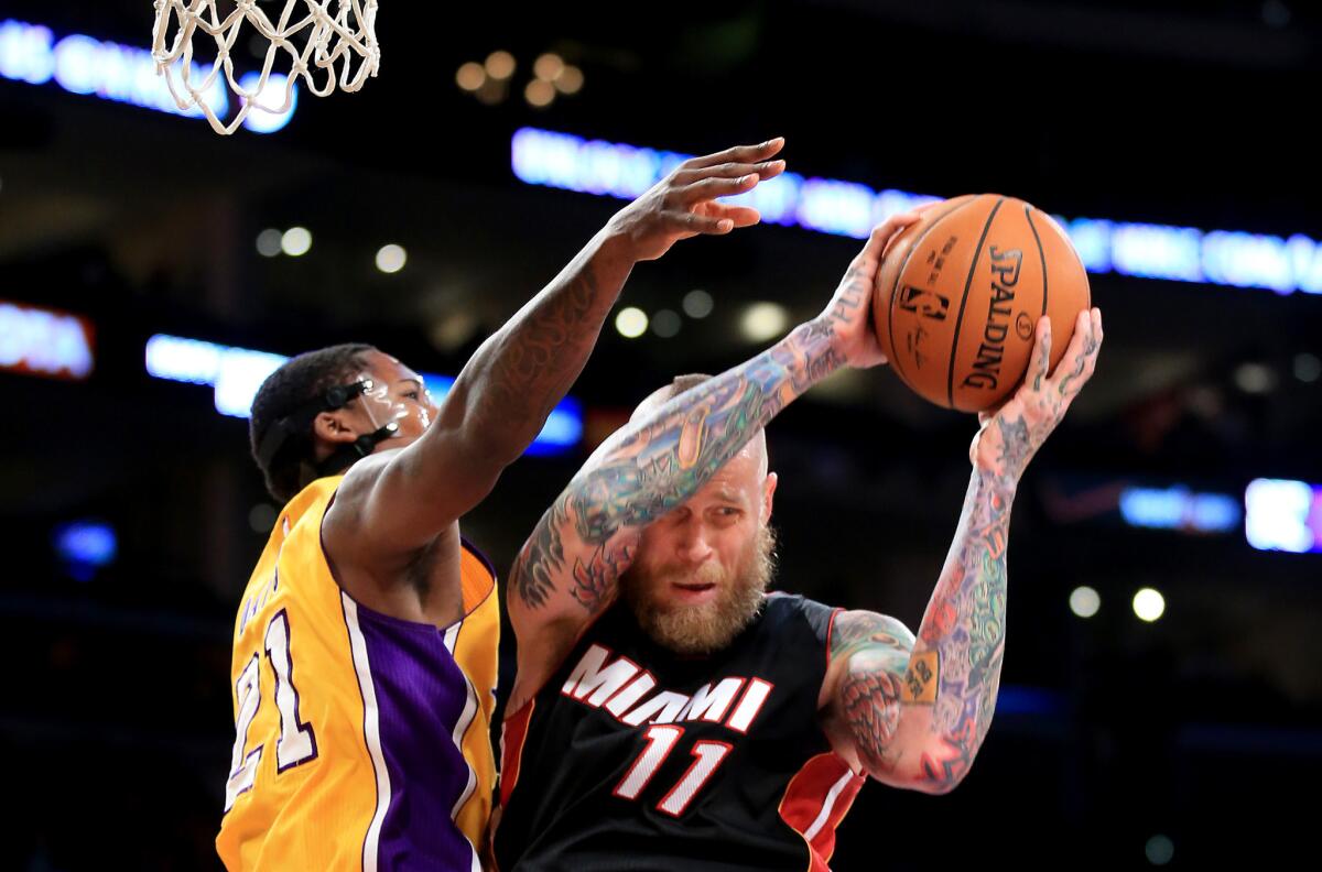Heat center Chris Anderson pulls down a rebound in front of Ed Davis during the first quarter of a game Tuesday at Staples Center.