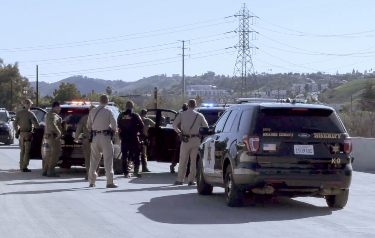 Orange County Sheriff’s deputies prepare to take a driver was taken into custody on the freeway