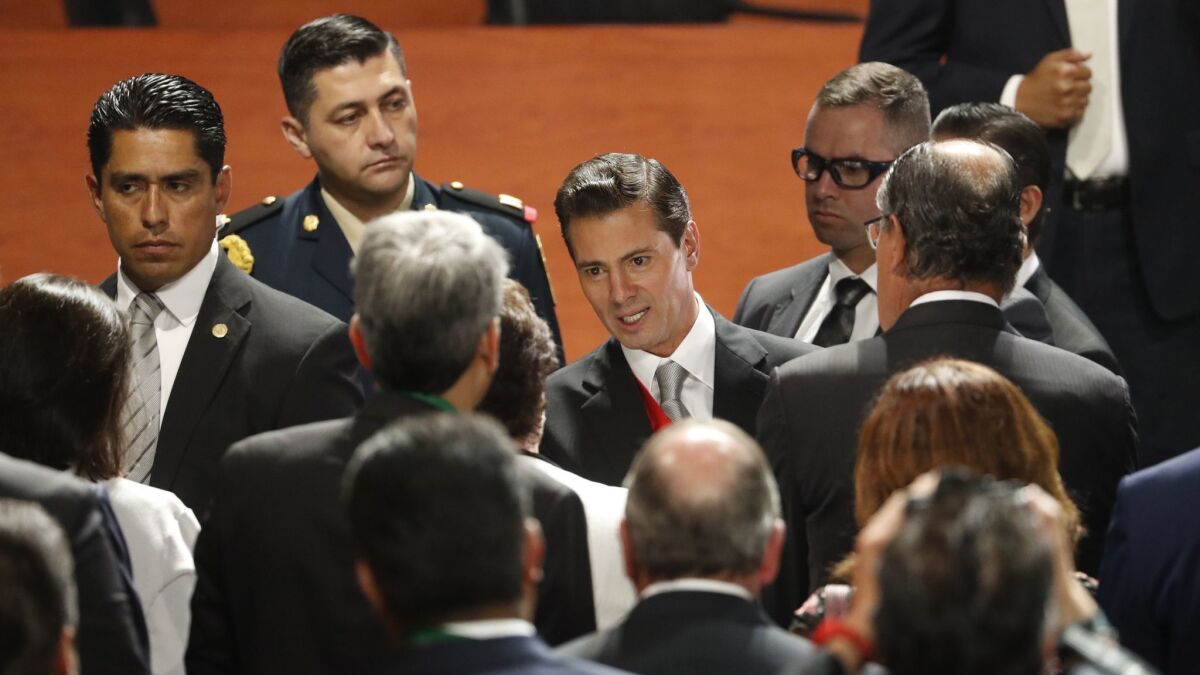 Mexican President Enrique Peña Nieto, center right, greets supporters after delivering his sixth and final State of the Nation address at the National Palace in Mexico City on Monday.