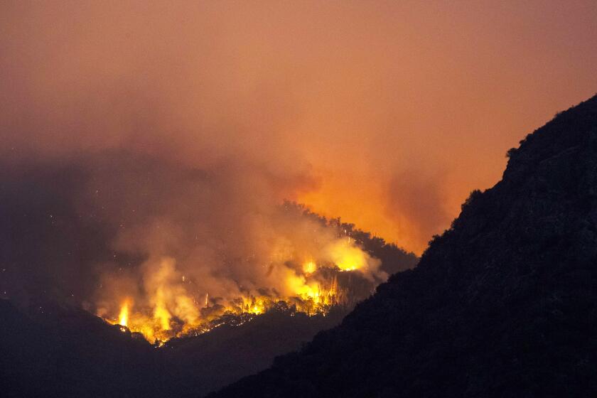 September 15, 2021: Flames burn through brush on a hillside near the entrance station to Sequoia National Park 