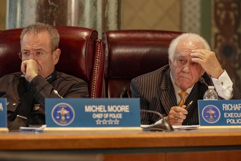 LOS ANGELES, CA JULY 24, 2018 -- LAPD Chief Michael Moore, left, and Richard Tefank, executive director, very attentively listen to speakers at a special meeting held by Los Angeles Police Commission on the LAPD's use of data in policing, including so-called predictive policing analysis that pinpoints crime hotspots and people who are at highest risk of committing more crimes.(Irfan Khan / Los Angeles Times)