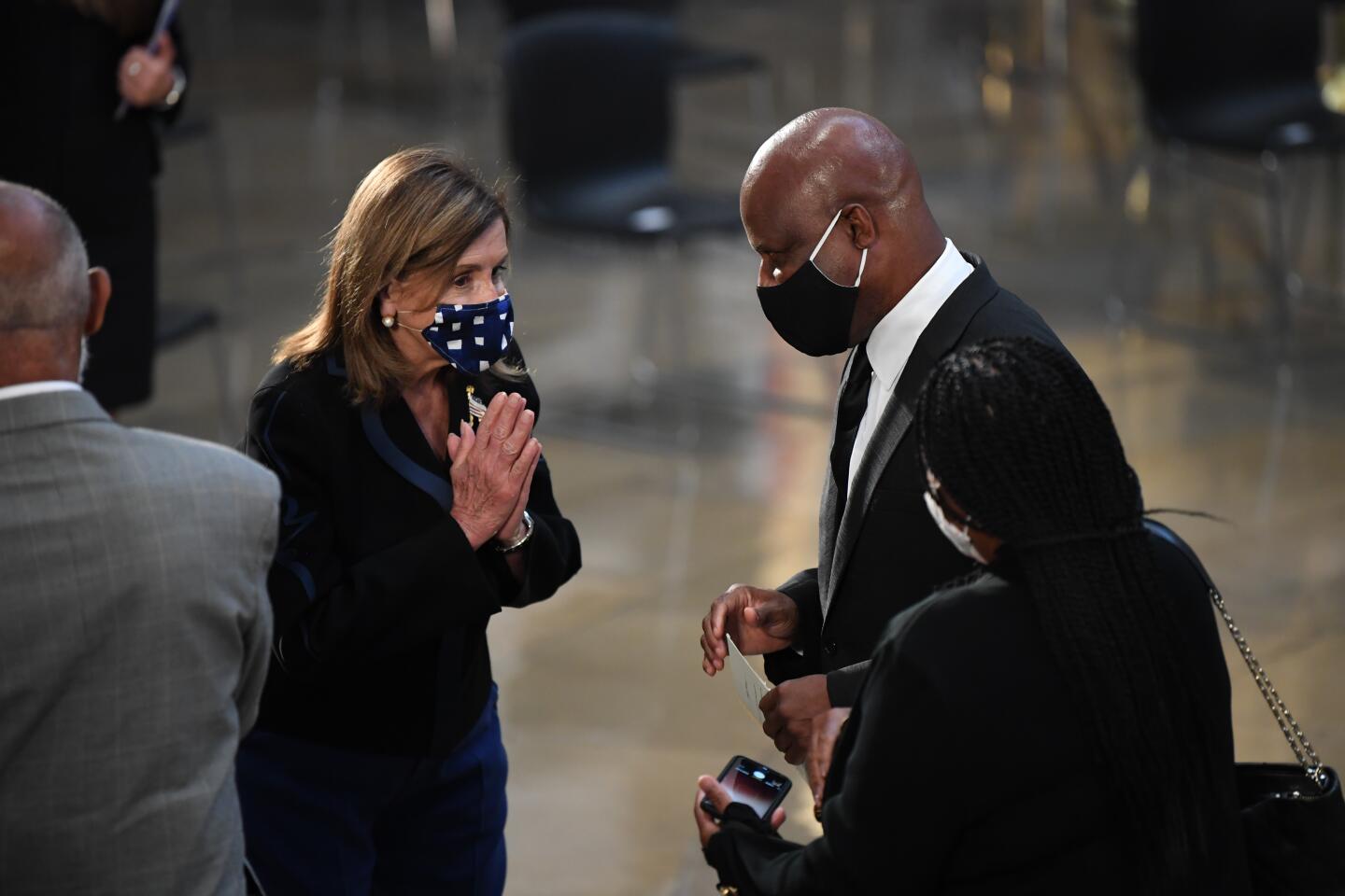 Speaker of the House Nancy Pelosi of Calif., speaks to family members in the Rotunda of the U.S., Capitol, during a service for Rep. John Lewis, D-Ga. Monday in Washington.