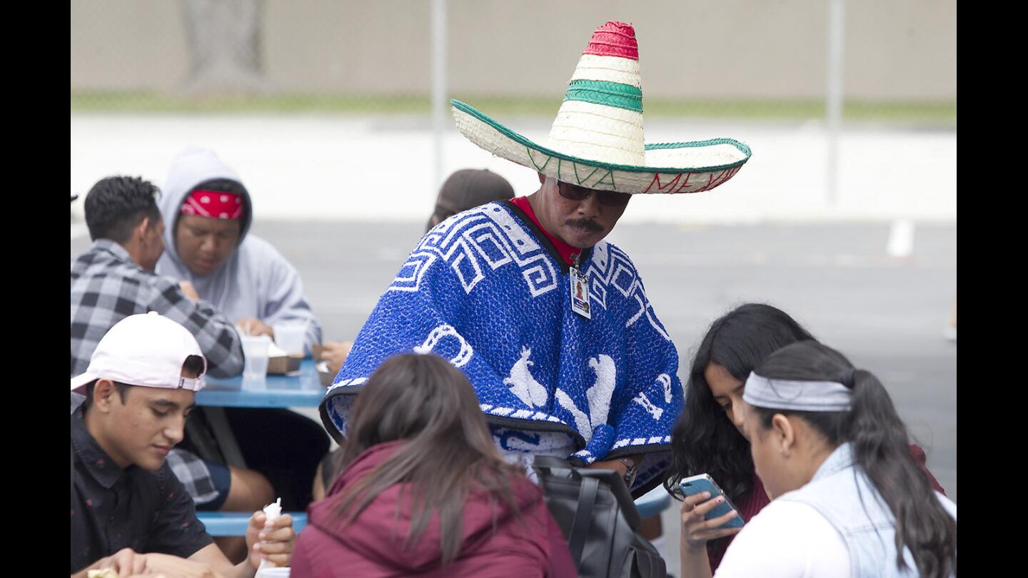 Wearing a sombrero and poncho, school security guard Liam Manokoune takes a seat with students as he celebrates Cinco de Mayo at Back Bay High. The lunch was catered by El Taco Bravo and sponsored by the Exchange Club of Newport Harbor.