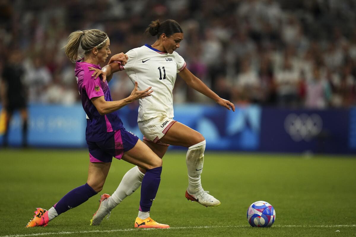 Germany's Kathrin Hendrich and the United States' Sophia Smith battle for the ball during a Summer Olympics group match