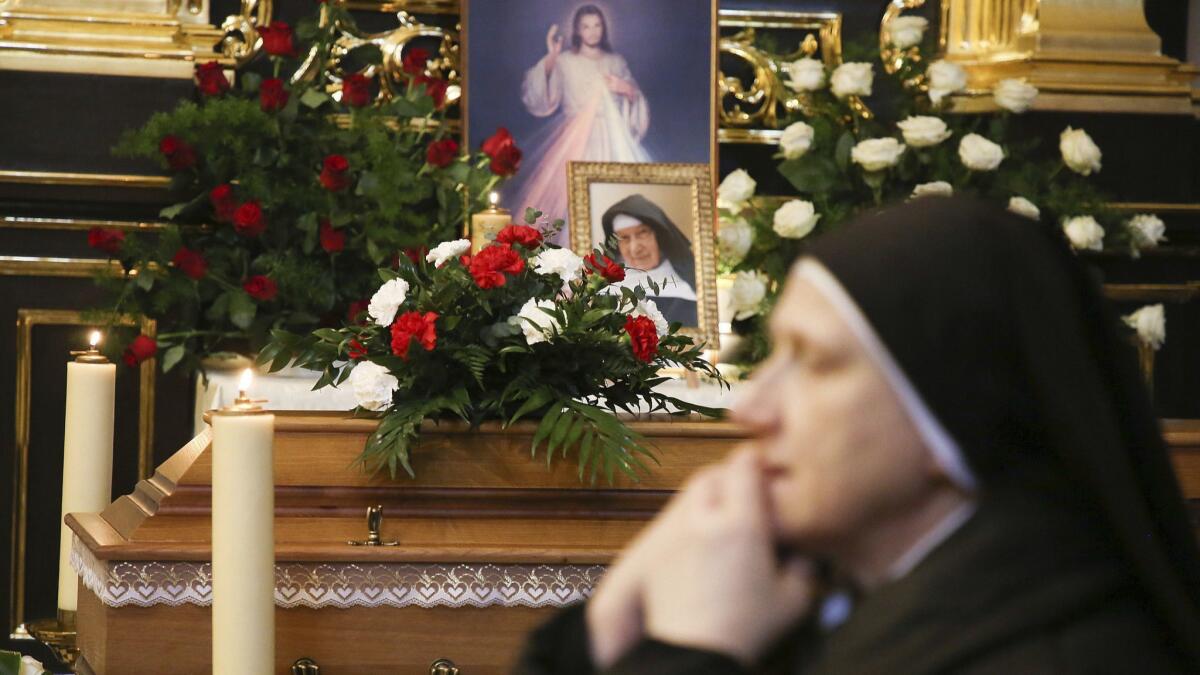 A nun prays Nov. 22 beside the casket and photo of 110-year-old Roman Catholic Sister Cecylia Roszak, believed to be the world's oldest nun, and a rescuer of Jews during the Holocaust.