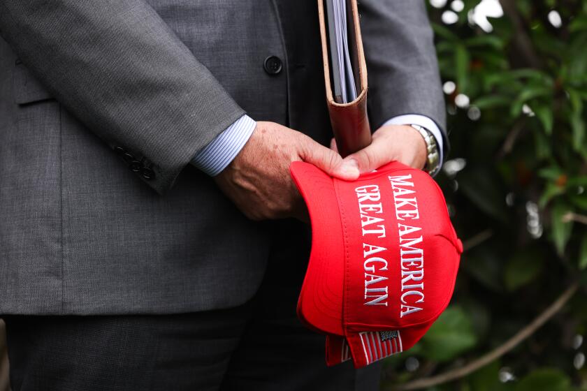 RANCHO PALOS VERDES-CA-SEPTEMBER 13, 2024: Rancho Palos Verdes Mayor John Cruikshank holds a MAGA hat while listening to former President Donald J. Trump, speak during a press conference at Trump National Golf Course on Friday, September 13, 2024. (Christina House / Los Angeles Times)